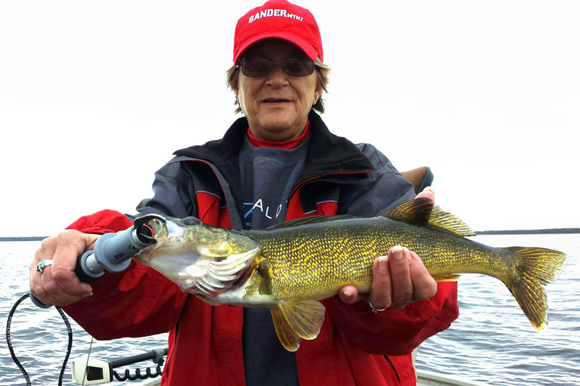 woman holding walleye caught on Lake Winnie in the fall